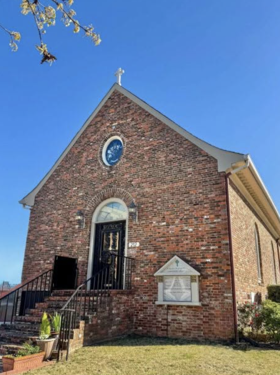 Red brick chapel with a round stained-glass window