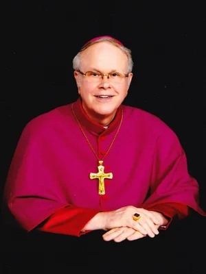Portrait of Archbishop Blair W. Schultz in magenta choir habit with pectoral cross